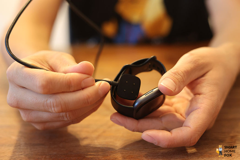 Man sieht das Ladekabel der Fitbit Versa 4.